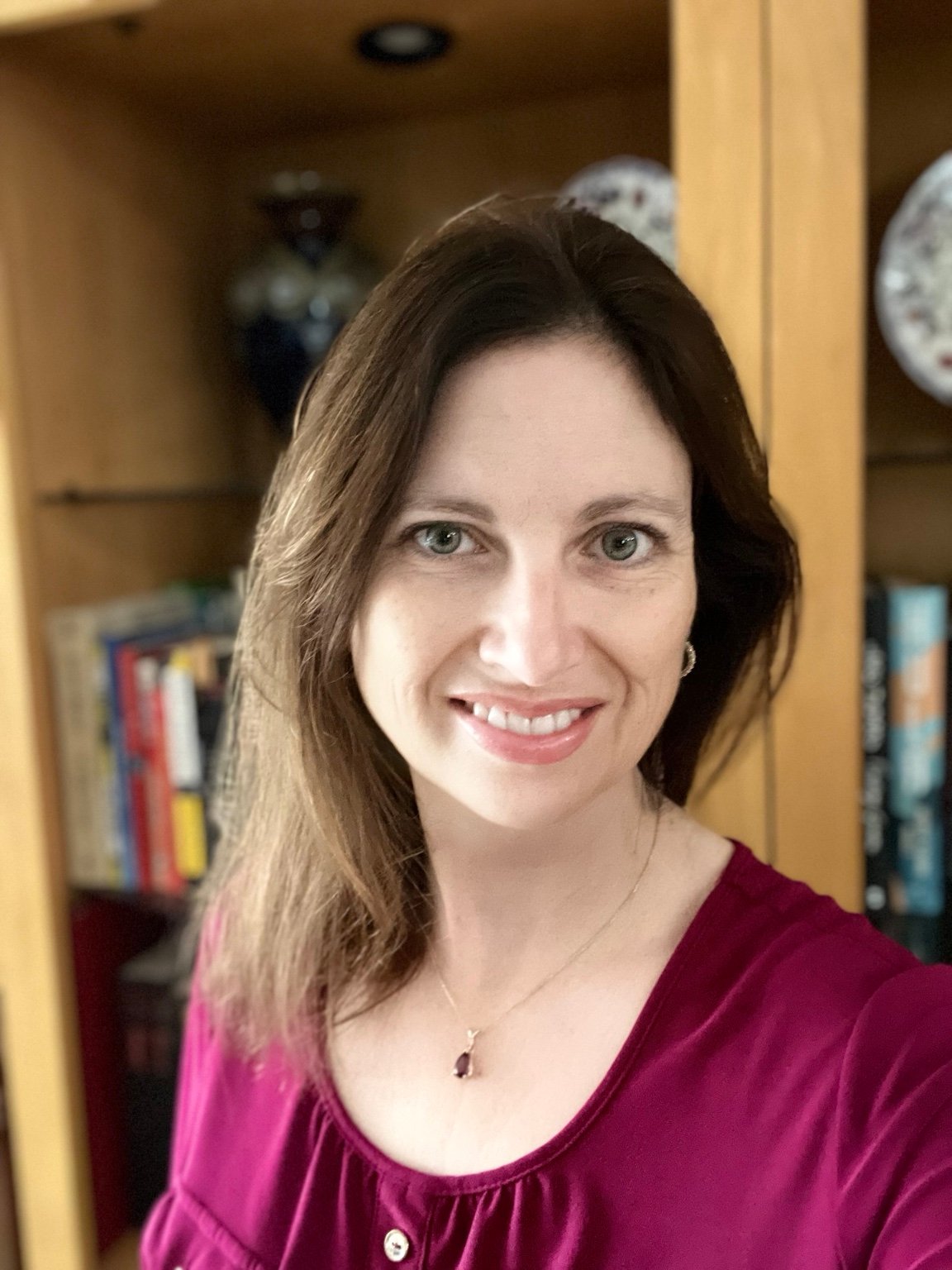 Amanda LaPera author portrait near a bookshelf.