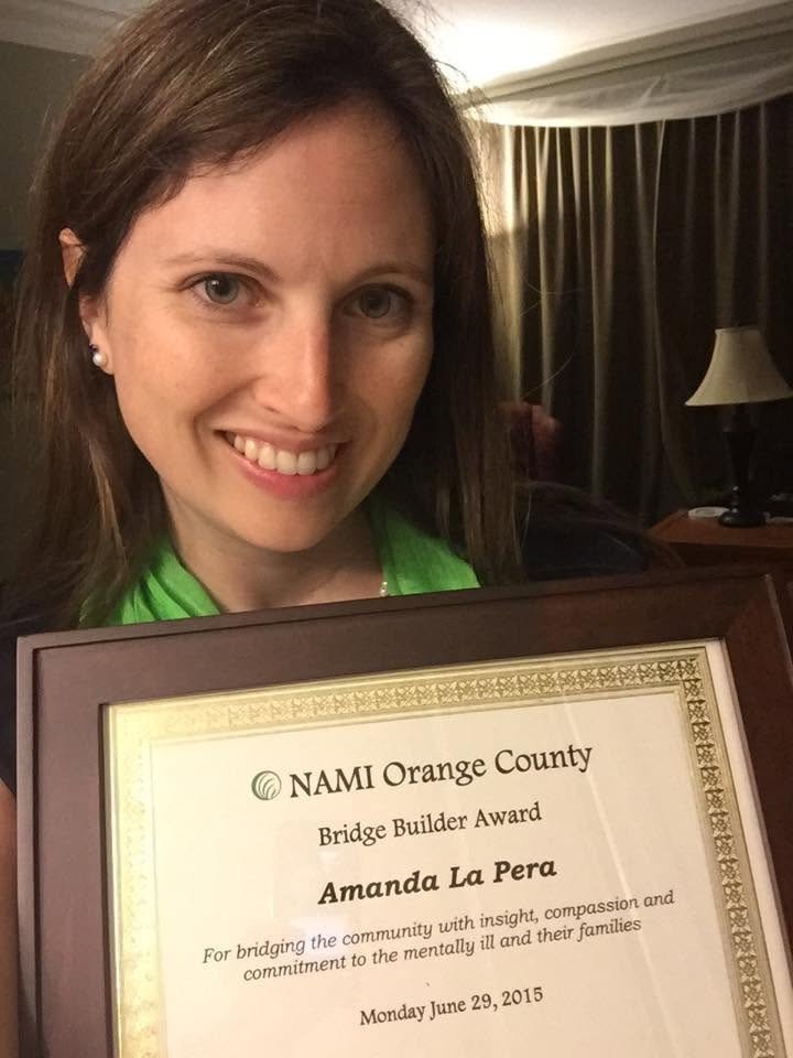 Amanda LaPera holding the NAMI Orange County Bridge Builder Award.